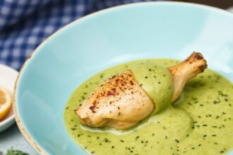 Peruvian chicken masterclass plate with creamy green sauce, cilantro, lime wedges.