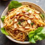 A bowl of crunchy Ramen Salad featuring colorful vegetables and golden toasted noodles.