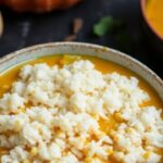 Silken pumpkin curry paired with fragrant jasmine rice and garnished with fresh herbs.