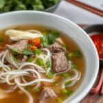 Steaming bowl of pho, a soulful Vietnamese beef noodle soup experience.