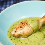 Peruvian chicken masterclass plate with creamy green sauce, cilantro, lime wedges.