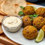 Golden falafel, vibrant dips, and fresh herbs create a perfect falafel platter.